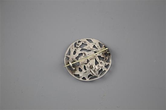 A late Victorian pierced white metal brooch, decorated with central mask amid foliage,